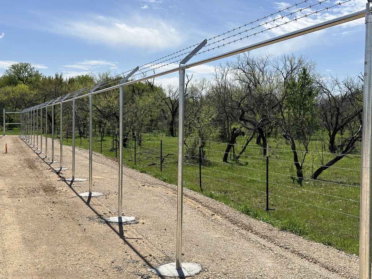 Fence with New Chain Link Fence Framework Installation – Galvanized Posts with Barbed Wire Arms in Fort Worth, TX