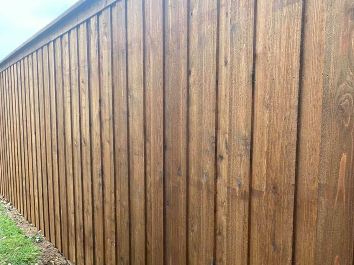 Fence with Stained board on board Wood fence with cap and trim installed by a fence company in Fort Worth TX in Fort Worth, TX